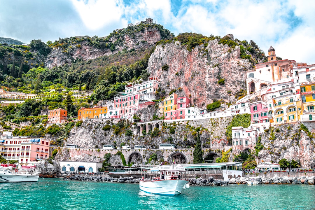 White boat on the water near the green and brown cliffs of Capri