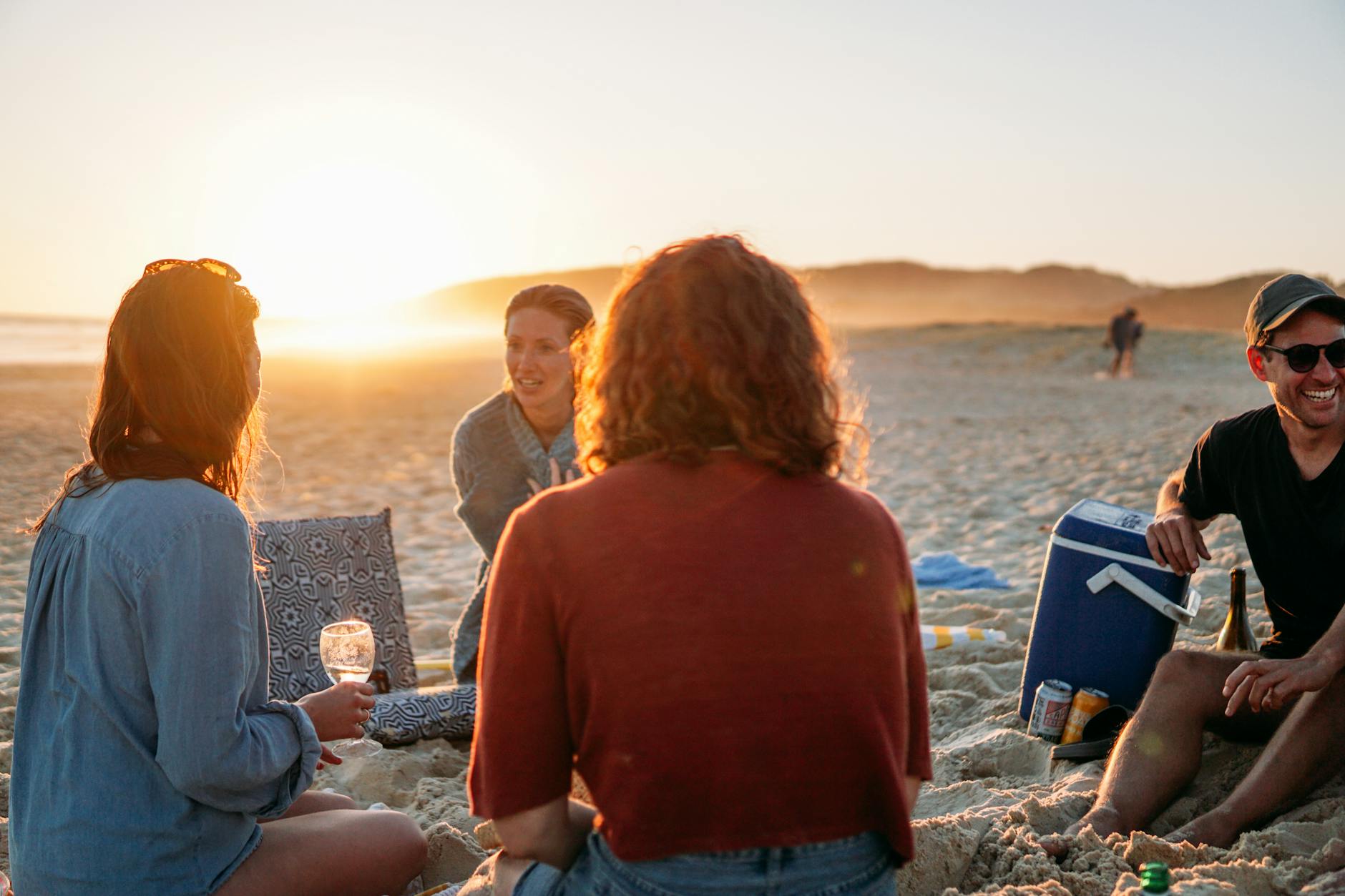 Group of women friends celebrating on a beach at sunset