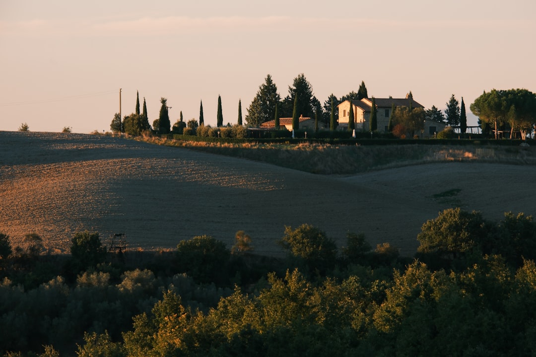 Tuscan farmhouse on rolling hills at sunset